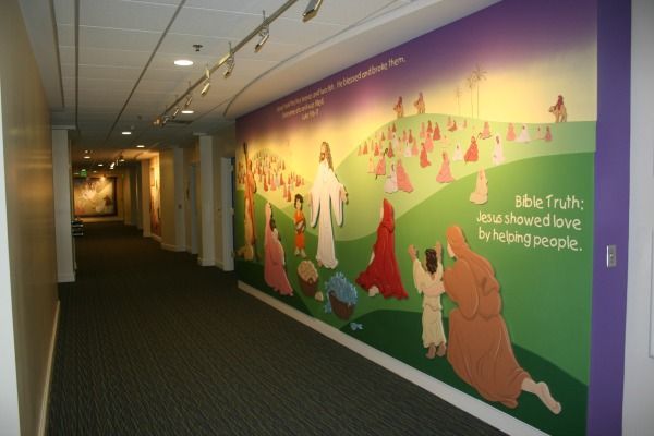 Hallway with a painted mural of Jesus and people, green hill, purple background.