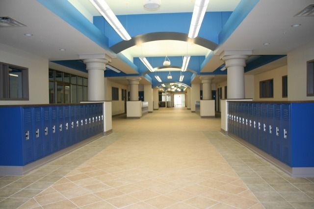 School hallway with blue lockers, columns, and ceiling details.