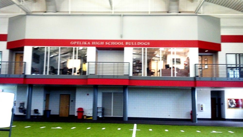 Opelika High School Bulldogs facility interior with red and white accents, featuring a second-floor balcony.
