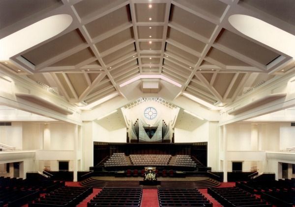 Interior view of a large auditorium with a stage, rows of seating, and a decorative ceiling.