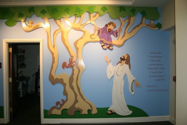 Mural of Jesus with arms outstretched, looking up at Zacchaeus in a tree. Blue sky, tan tree, and a doorway.