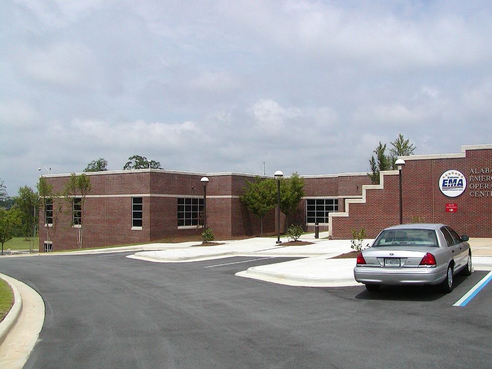 Brick building with car parked out front, blue sky.