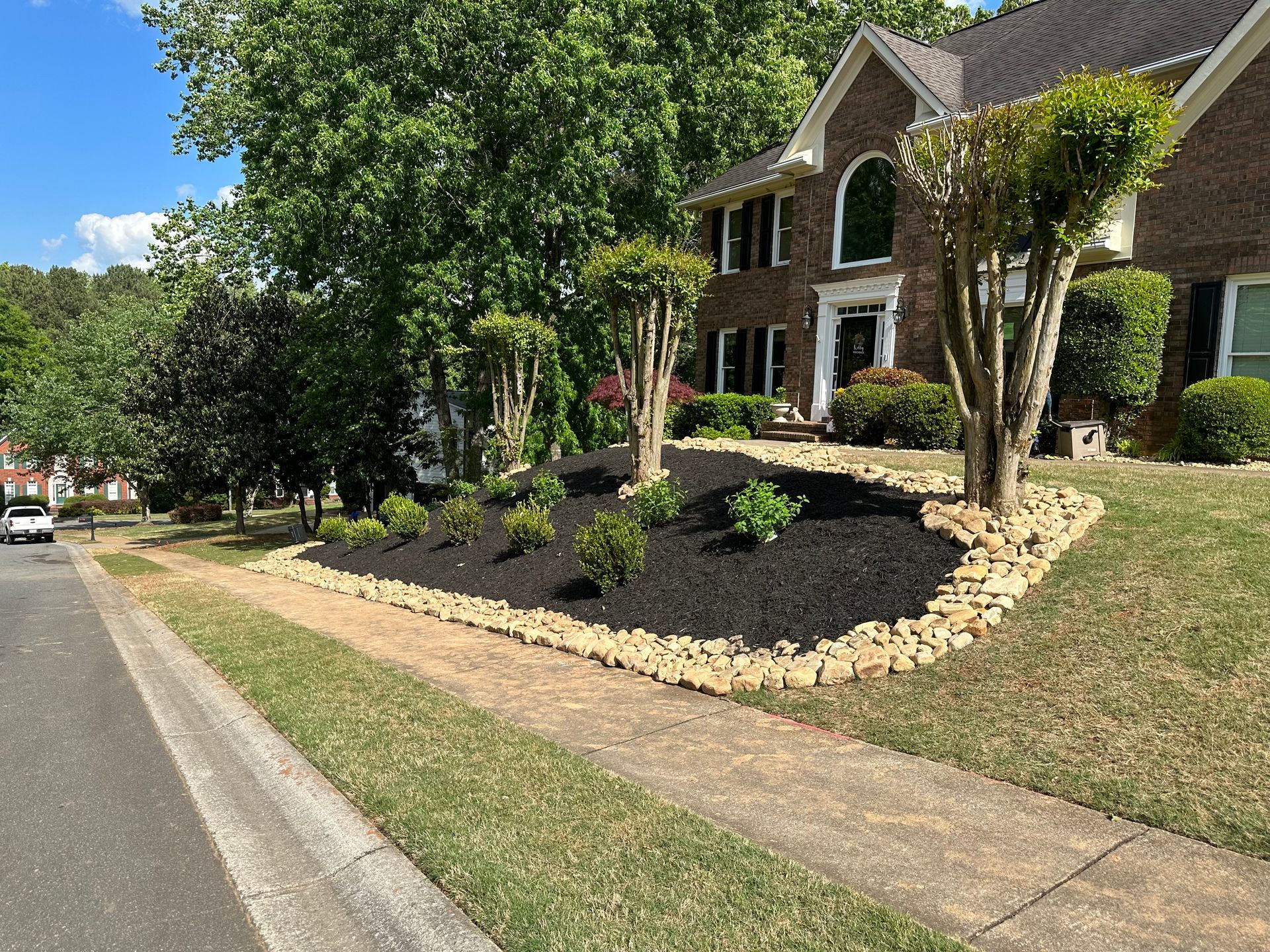 Freshly landscaped front yard with stone edging by RC Landscapes.