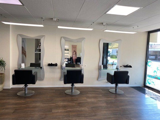 Eine Frau macht in einem Friseursalon ein Foto von sich im Spiegel.