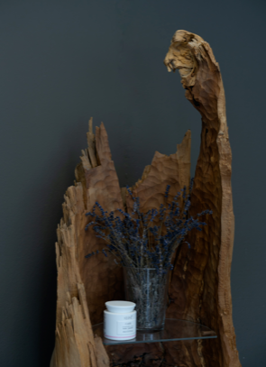 Ein Holzregal mit einer Blumenvase darauf.