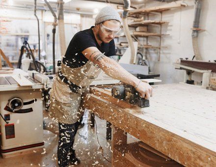 Commercial and Residential Cabinet Company — Man Sawing Wood in Farmingdale, NJ