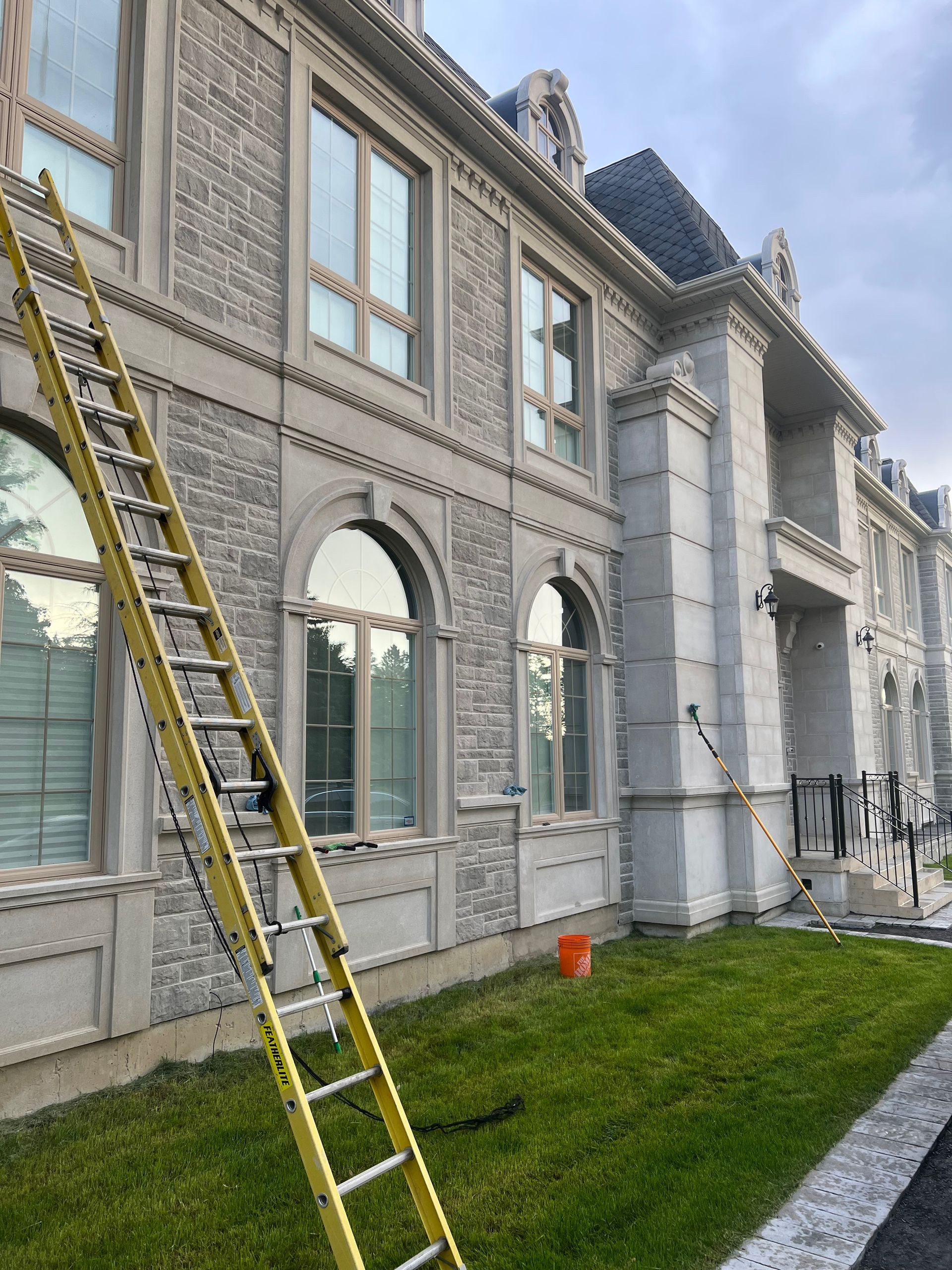 A yellow ladder is leaning against the side of a large building.