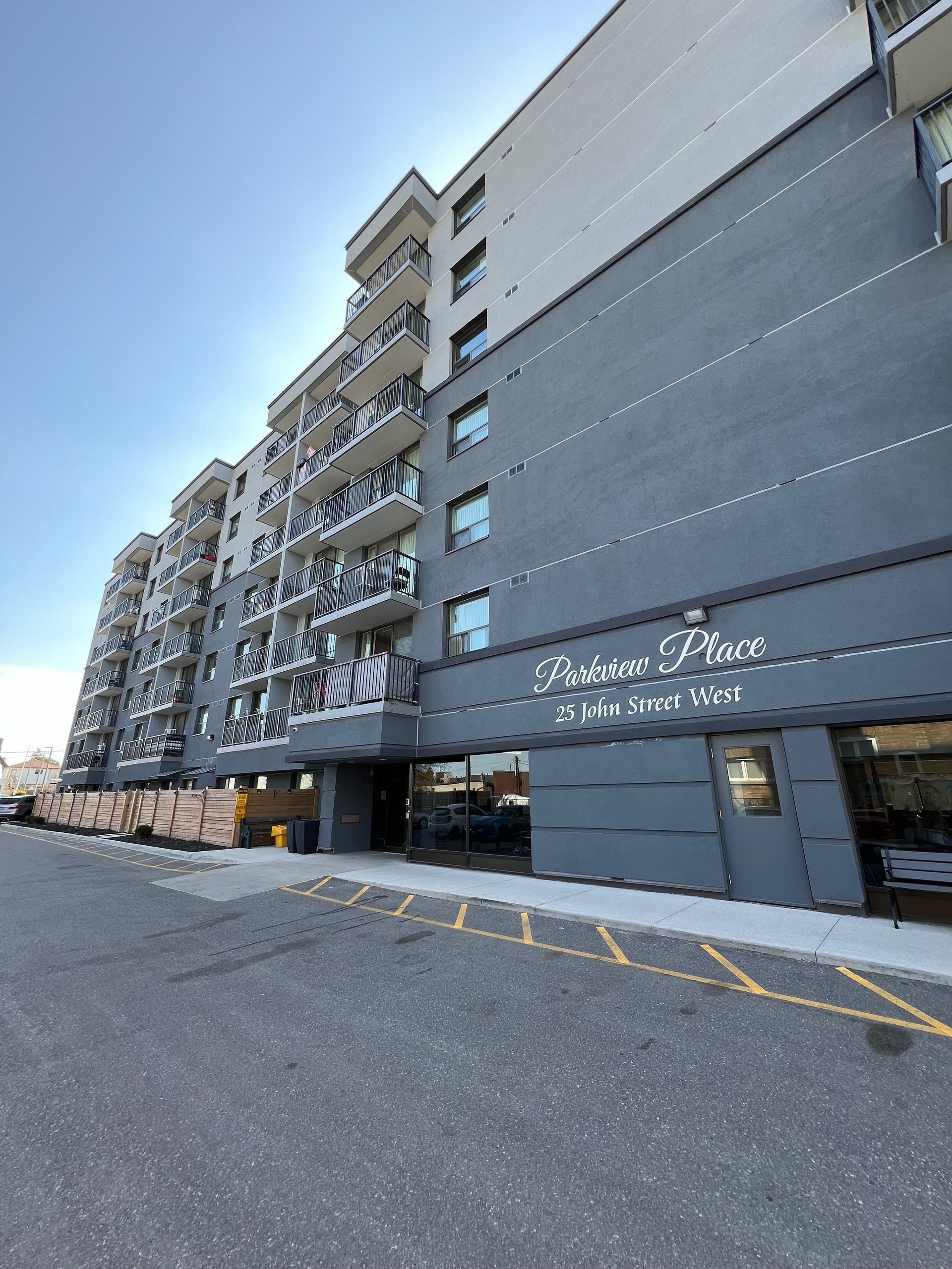 A large building with a lot of windows and a parking lot in front of it.