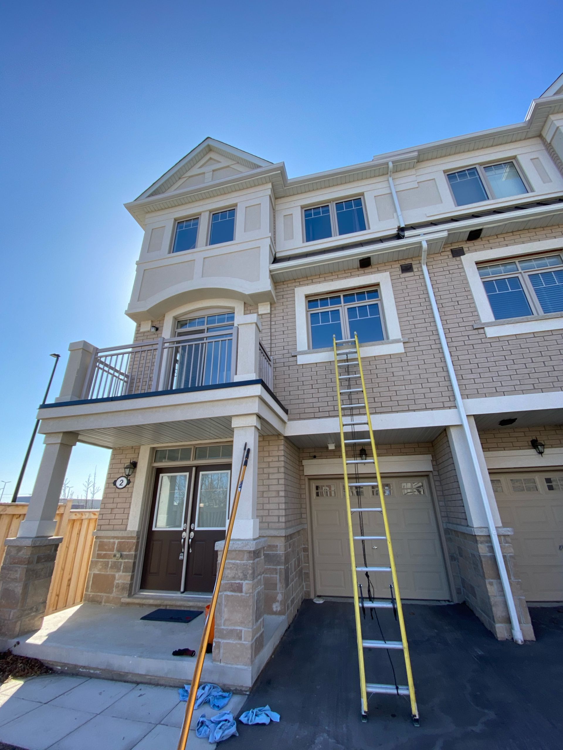 A ladder is sitting in front of a large house.