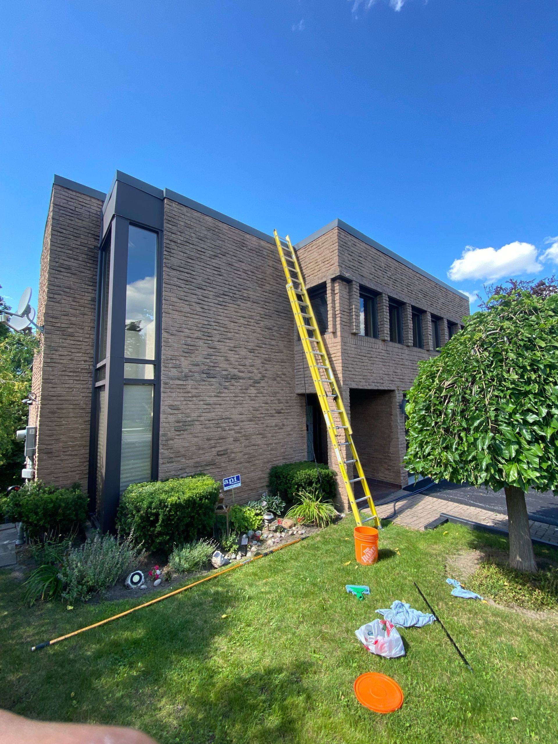 A ladder is sitting in front of a large brick building.