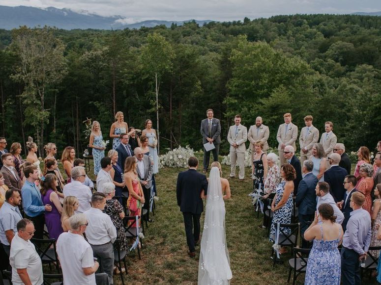 Outdoor wedding ceremony in North Carolina mountains at Serenity Ridge with couple exchanging vows.