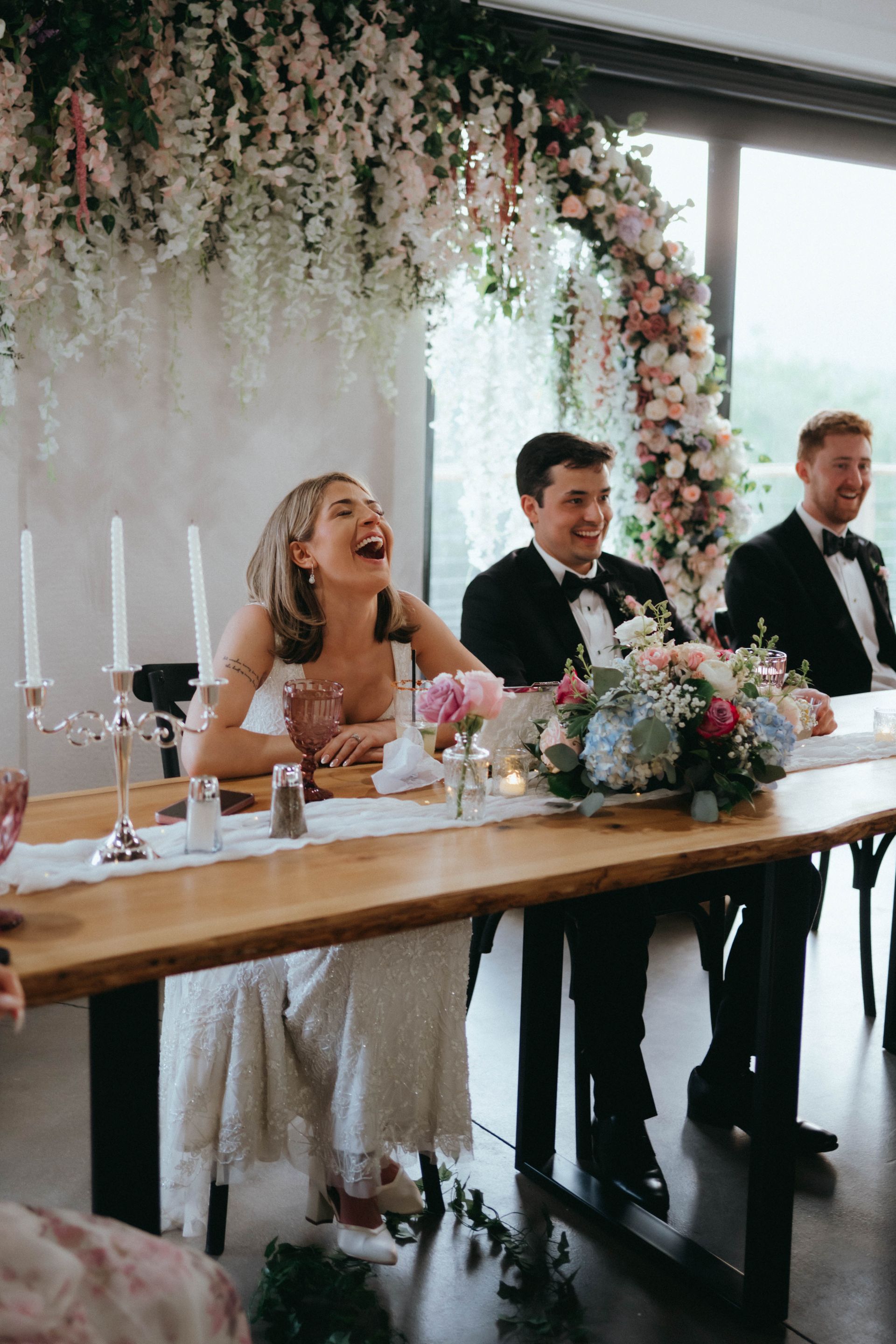 Bride and groom seated at sweetheart table during elegant wedding reception celebration