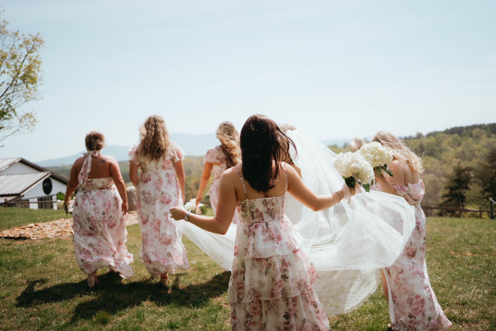 Bridesmaids celebrating together on ceremony lawn during outdoor wedding weekend near Asheville