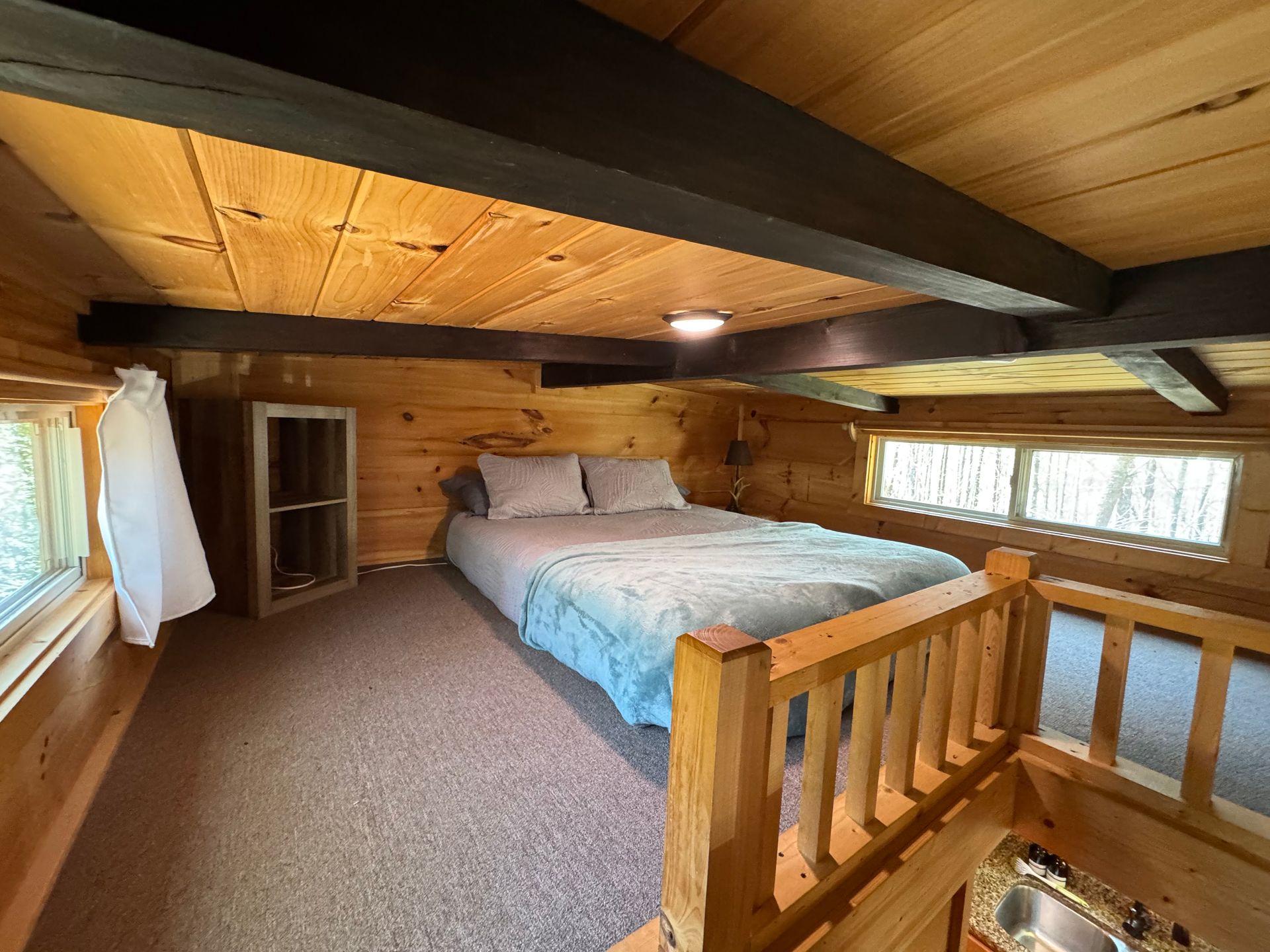 Loft bedroom with queen bed in Cabin F at Serenity Ridge