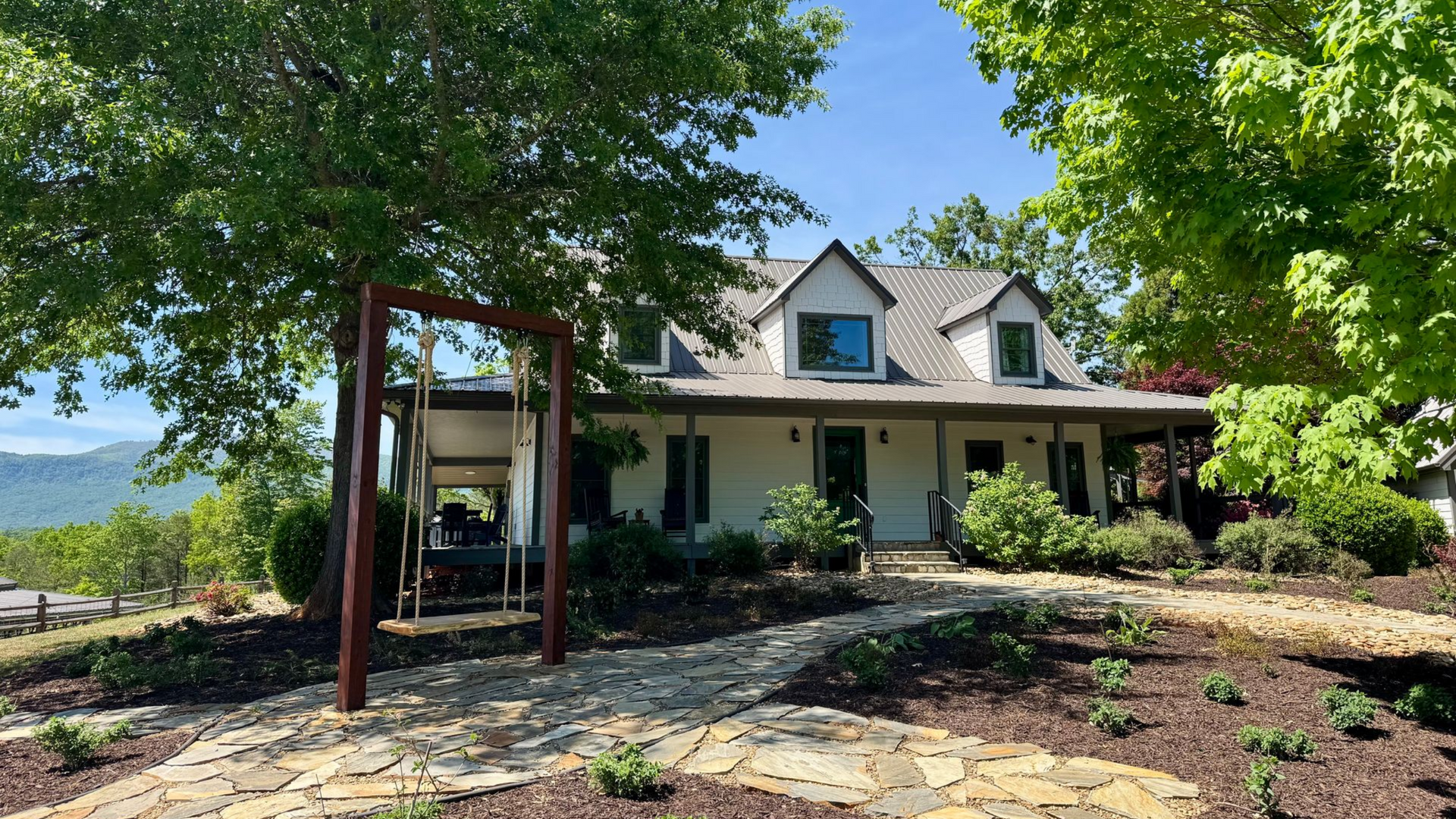 Hilltop House at Serenity Ridge, front view of home's gardens with NC mountains  as backdrop