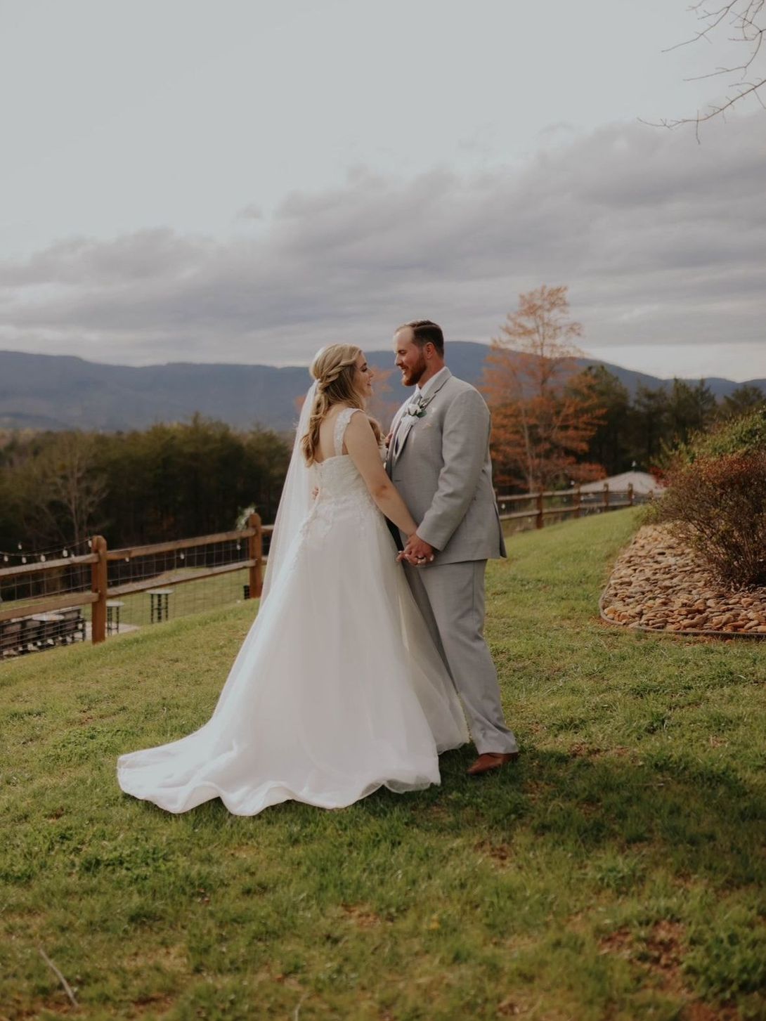 Just married couple posing at Serenity Ridge with panoramic mountain views in the background.