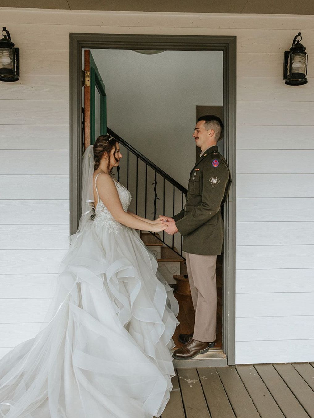 Couple standing happily in the doorway of Hilltop House at Serenity Ridge, framed by warm natural light and mountain views.
