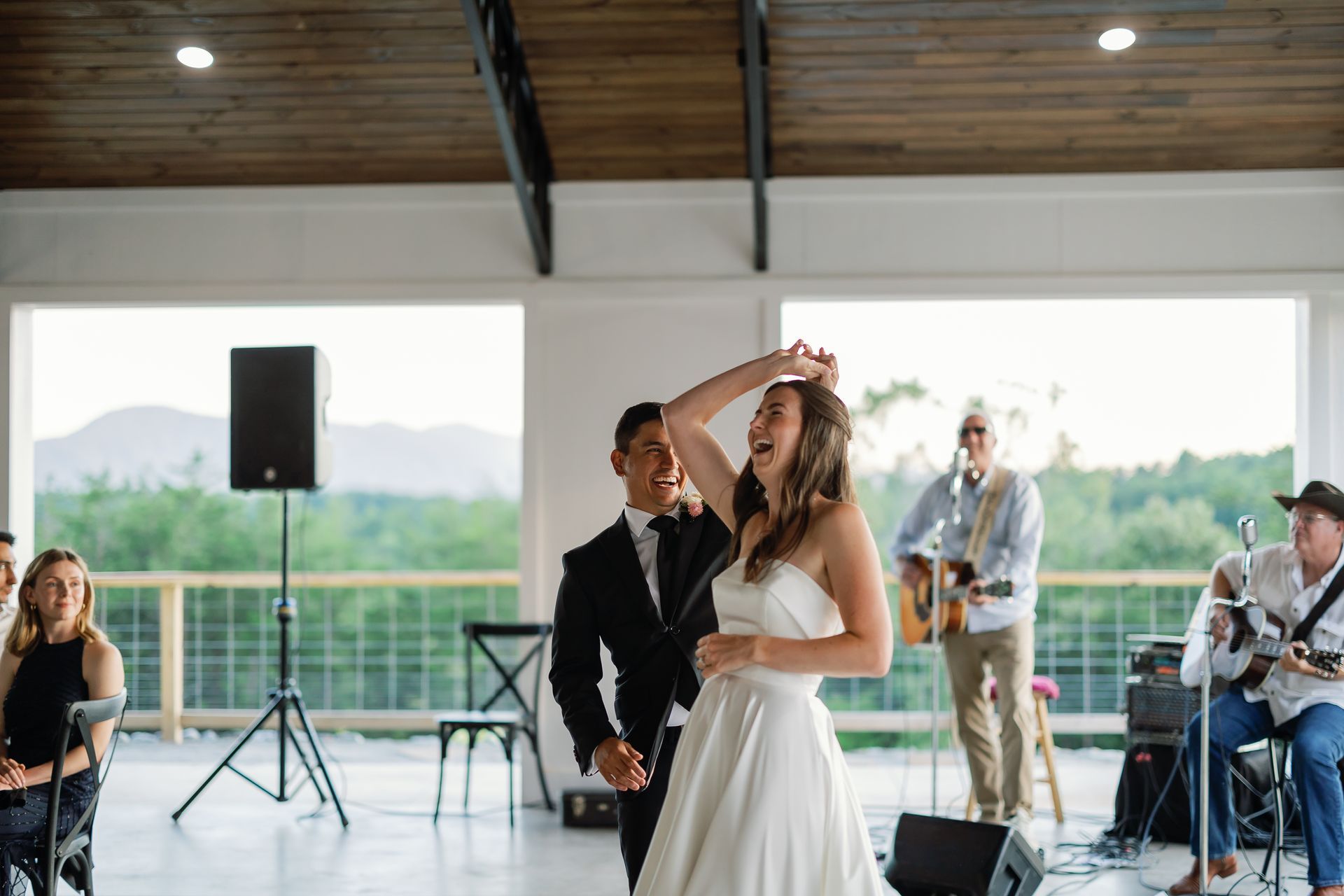 Couple dancing in Serenity Ridge’s event pavilion, live band playing in the background and modern mountain charm.
