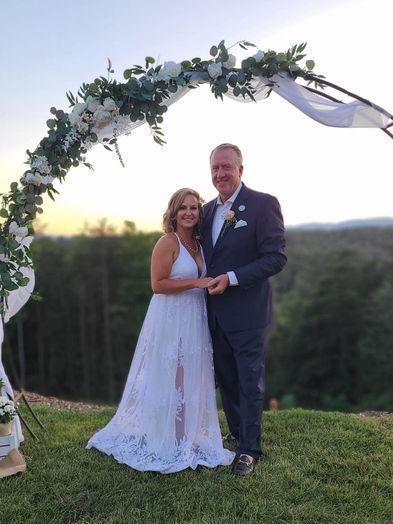 couple smiling beneath our wedding arch during Blue Ridge Mountain elopement at Serenity Ridge