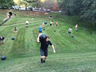 A group of people are doing exercises in a grassy field