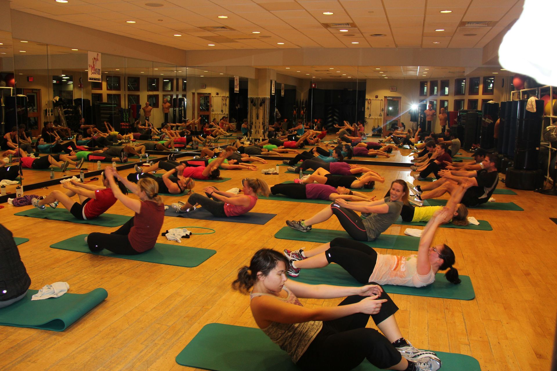 A group of people are doing exercises in a gym