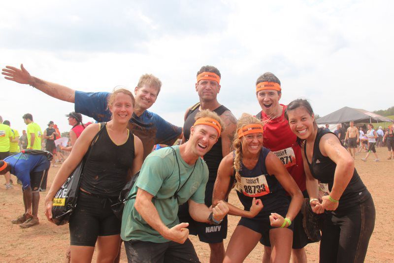 A group of people are posing for a picture in a dirt field