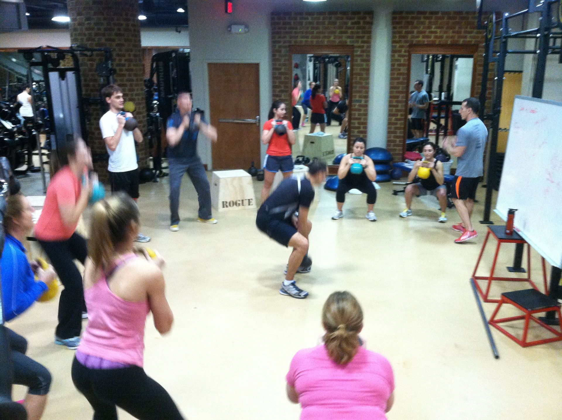 A group of people are doing squats in a gym