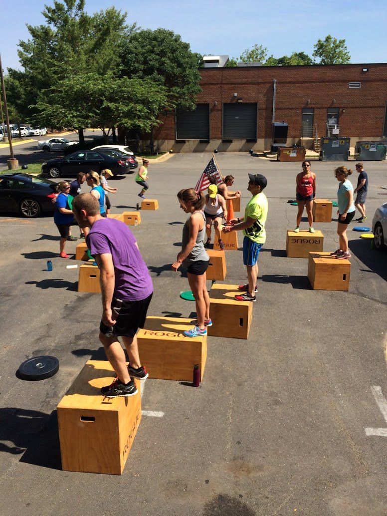 A group of people are standing on boxes in a parking lot