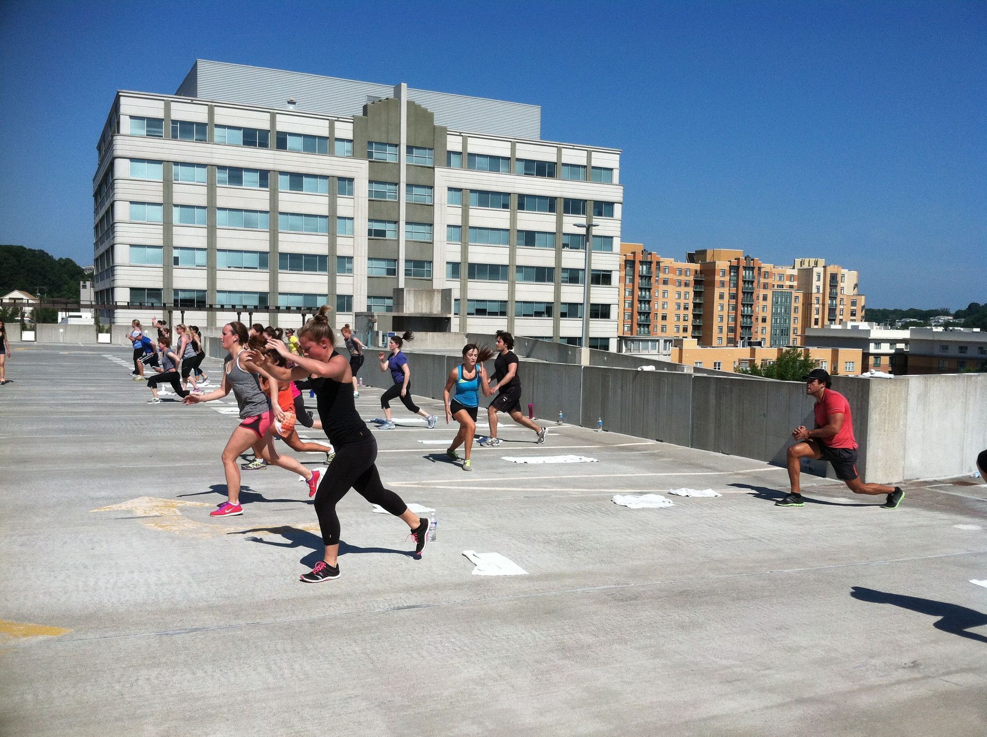 A group of people are doing exercises on the roof of a building