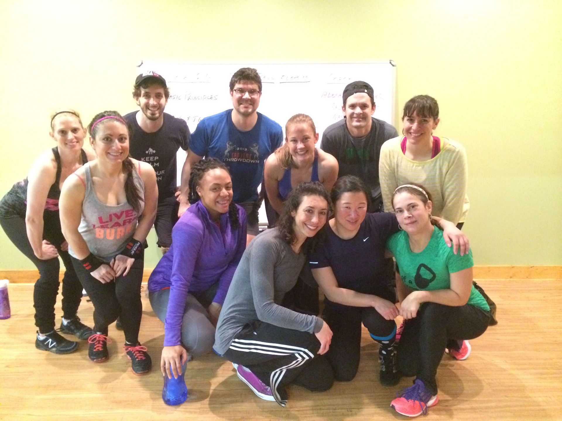A group of people are posing for a picture in a gym