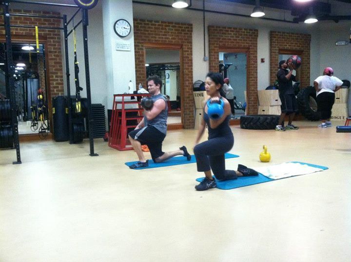 A man and a woman are doing exercises in a gym