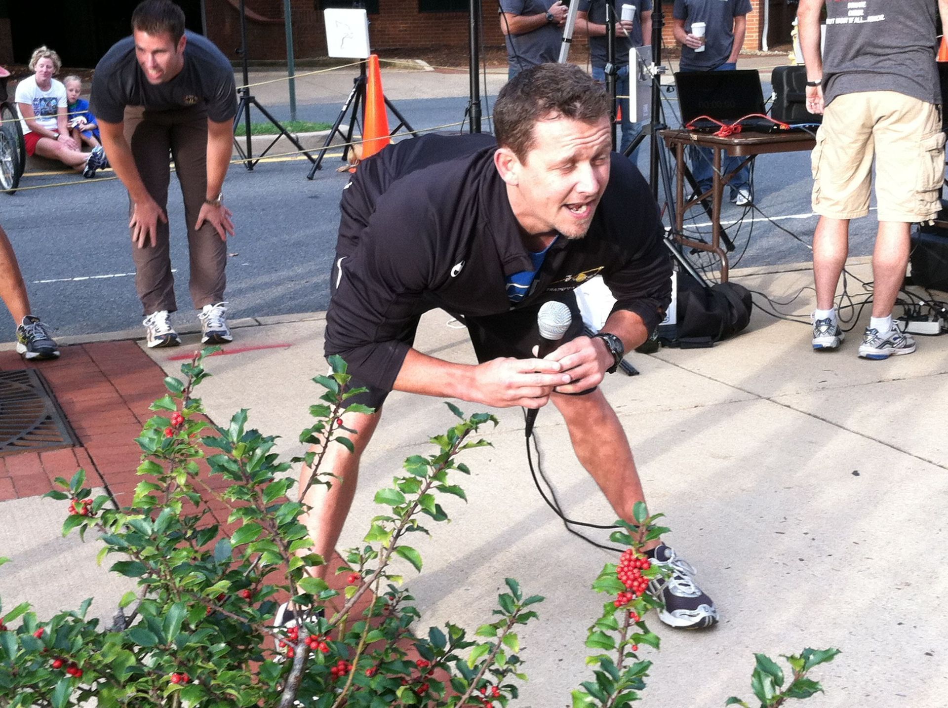 A man kneeling down with a microphone in his hand