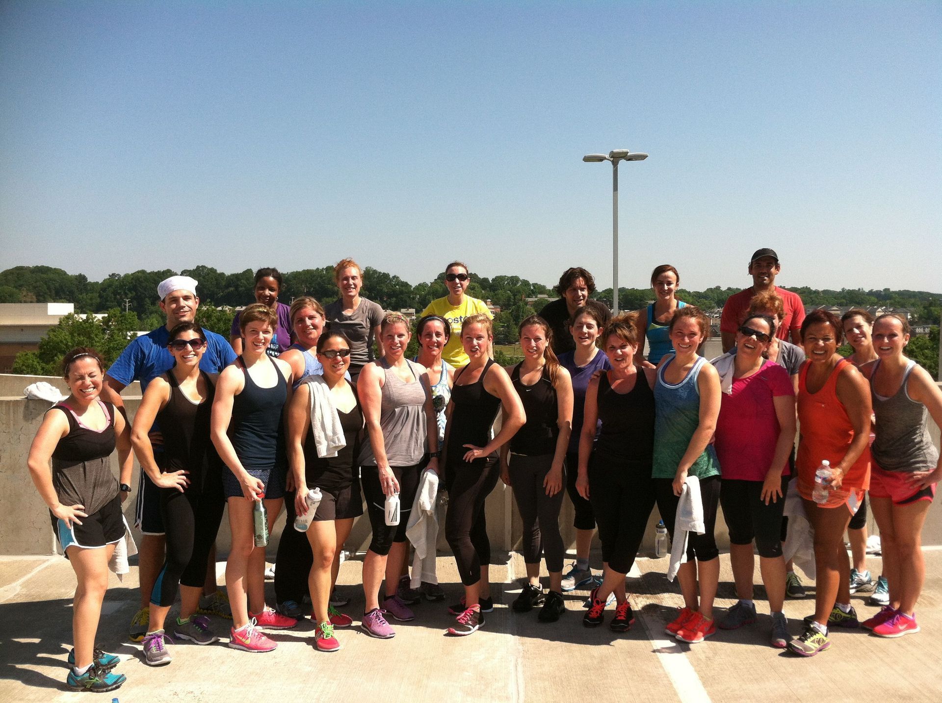 A group of people are posing for a picture in a parking lot