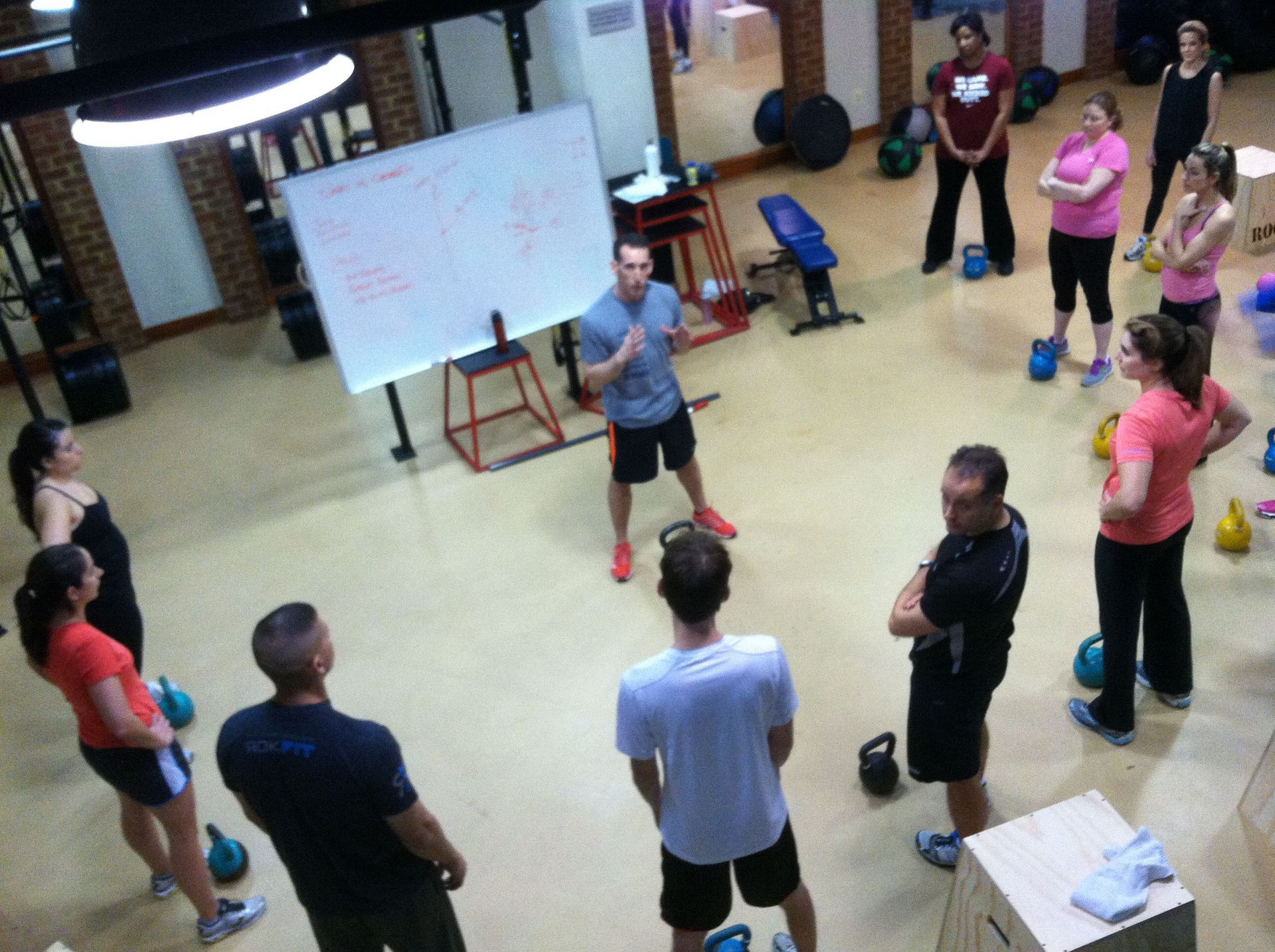 A group of people are standing in a circle in a gym