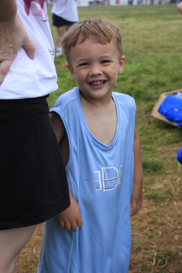 A young boy wearing a blue tank top with the letter b on it