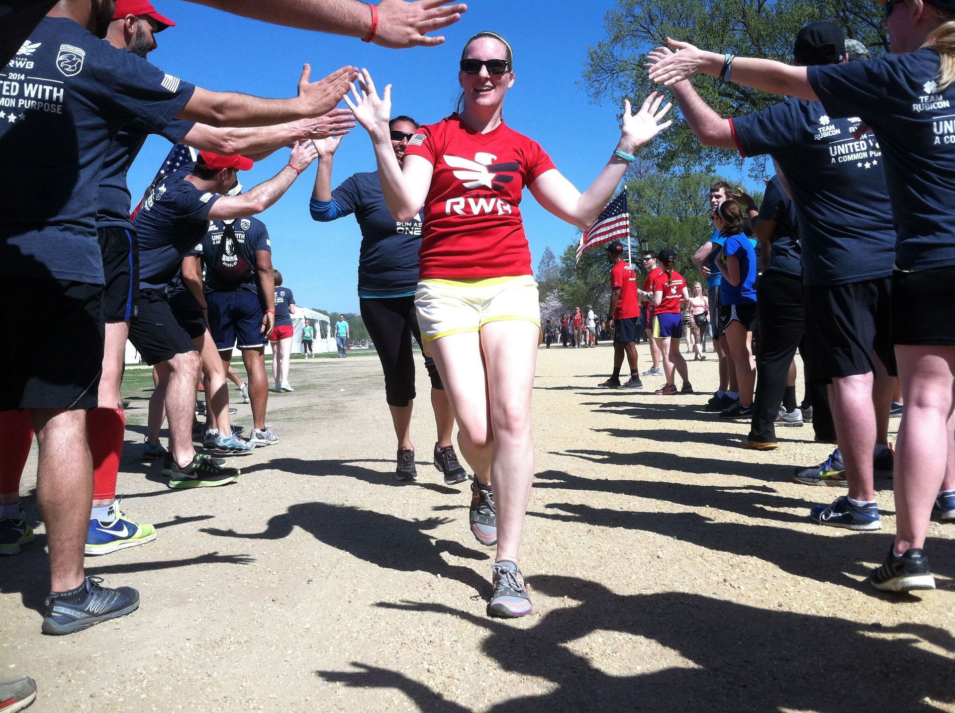 A woman in a red rw shirt is surrounded by people