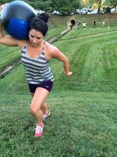 A woman is carrying a large ball on her back