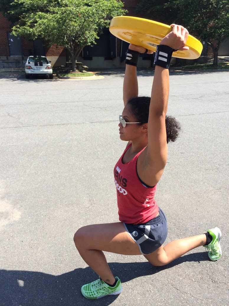 A woman dressed in a red shirt holds a vibrant yellow frisbee