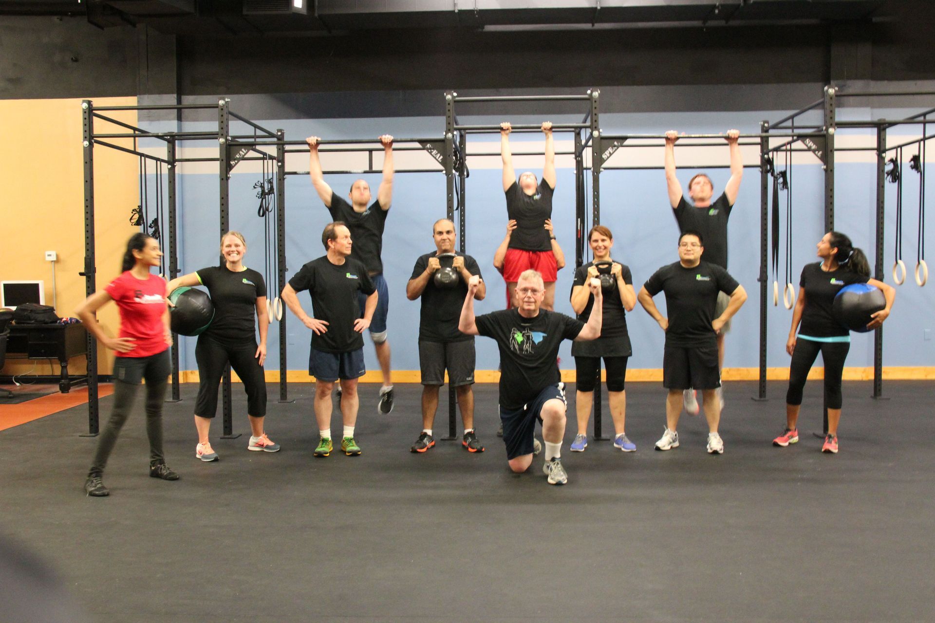 A group of people are posing for a picture in a gym