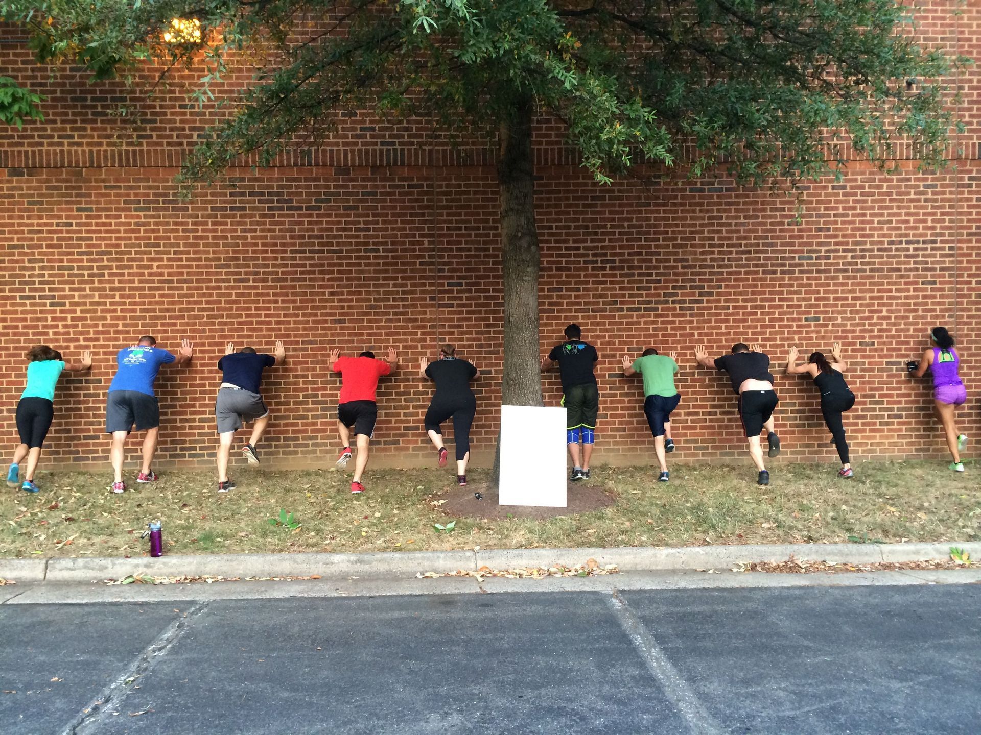 A group of people are climbing a brick wall