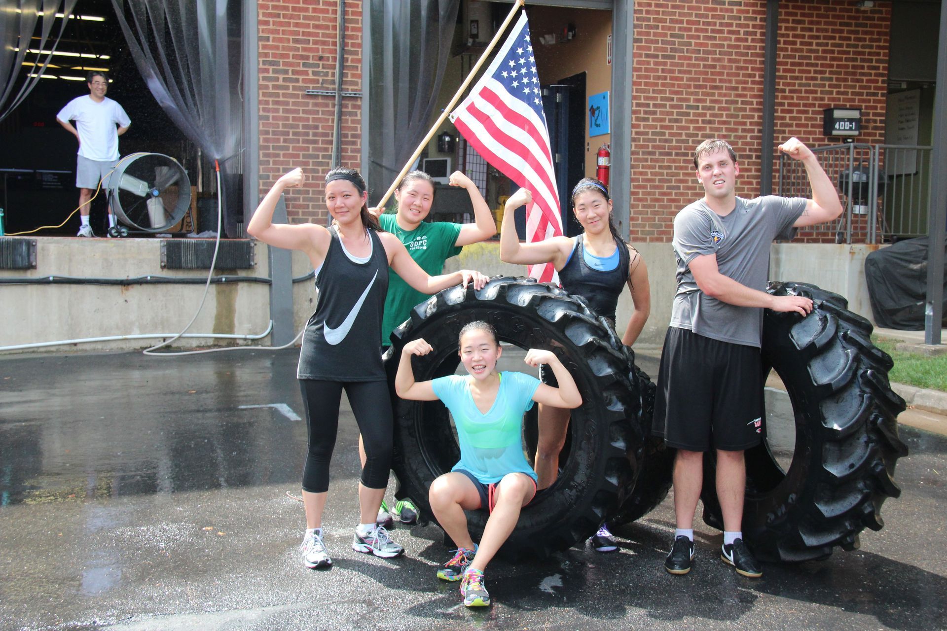 A group of people posing with a tire and an American flag