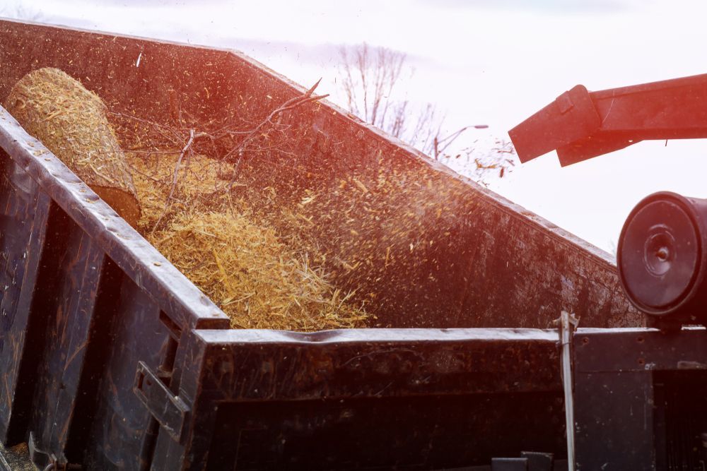 Wood chipper blowing wood chips into a truck bed.