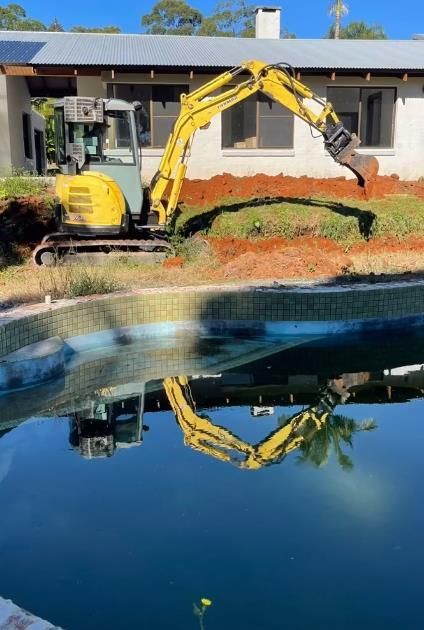 Yellow Excavator Near a House, Digging Earth Beside a Pool — Heller Excavation & Tree Services in Byron Bay, NSW