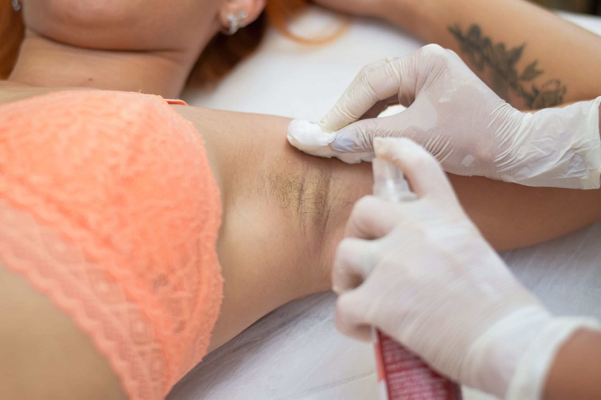 Uma mulher de biquíni está depilando as axilas.