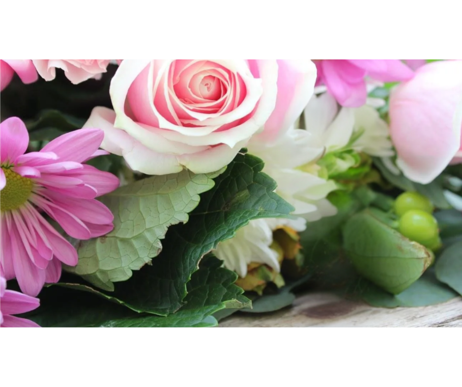 A close up of a bouquet of pink and white flowers on a table.