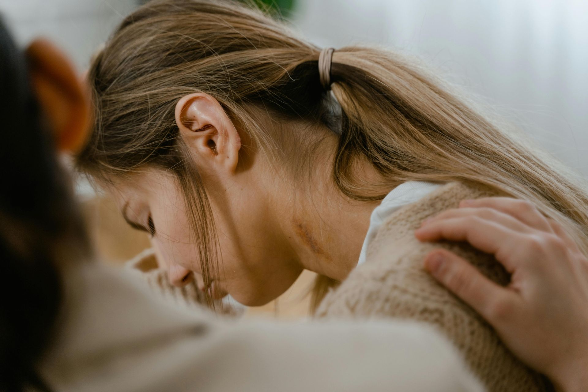 A woman is sitting on a couch with her head on a man 's shoulder.