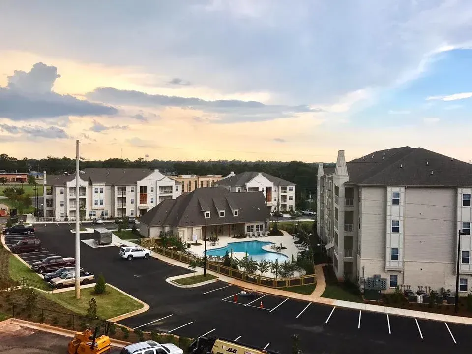 a large white house with a parking lot in front of it