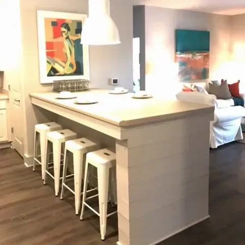 a kitchen with stools and a painting on the wall
