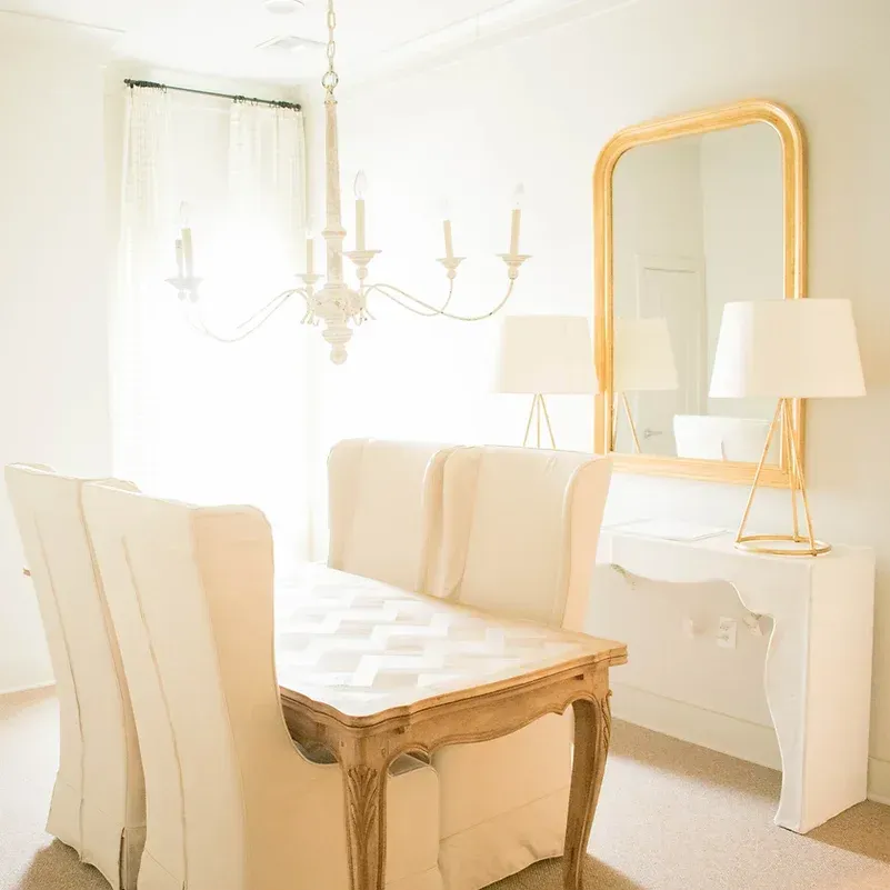 a dining room with a table and chairs and a mirror .