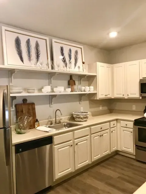 a kitchen with white cabinets and stainless steel appliances